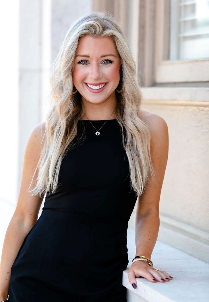 woman in black dress standing at building