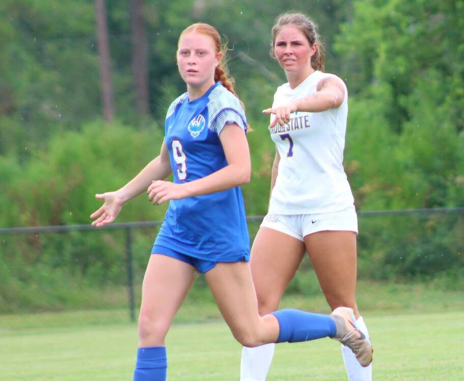 two females playing soccer