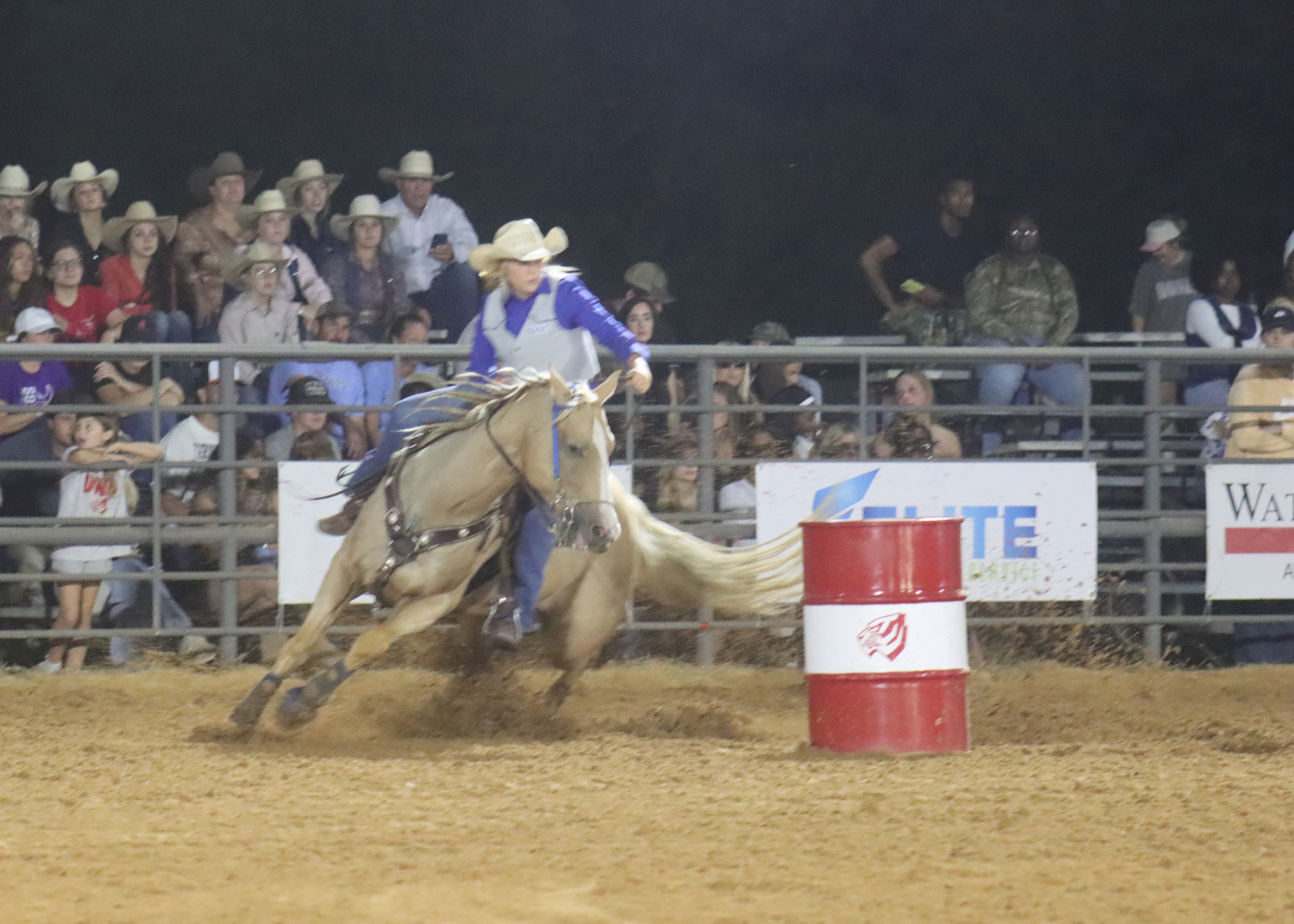 student riding a horse around barrels